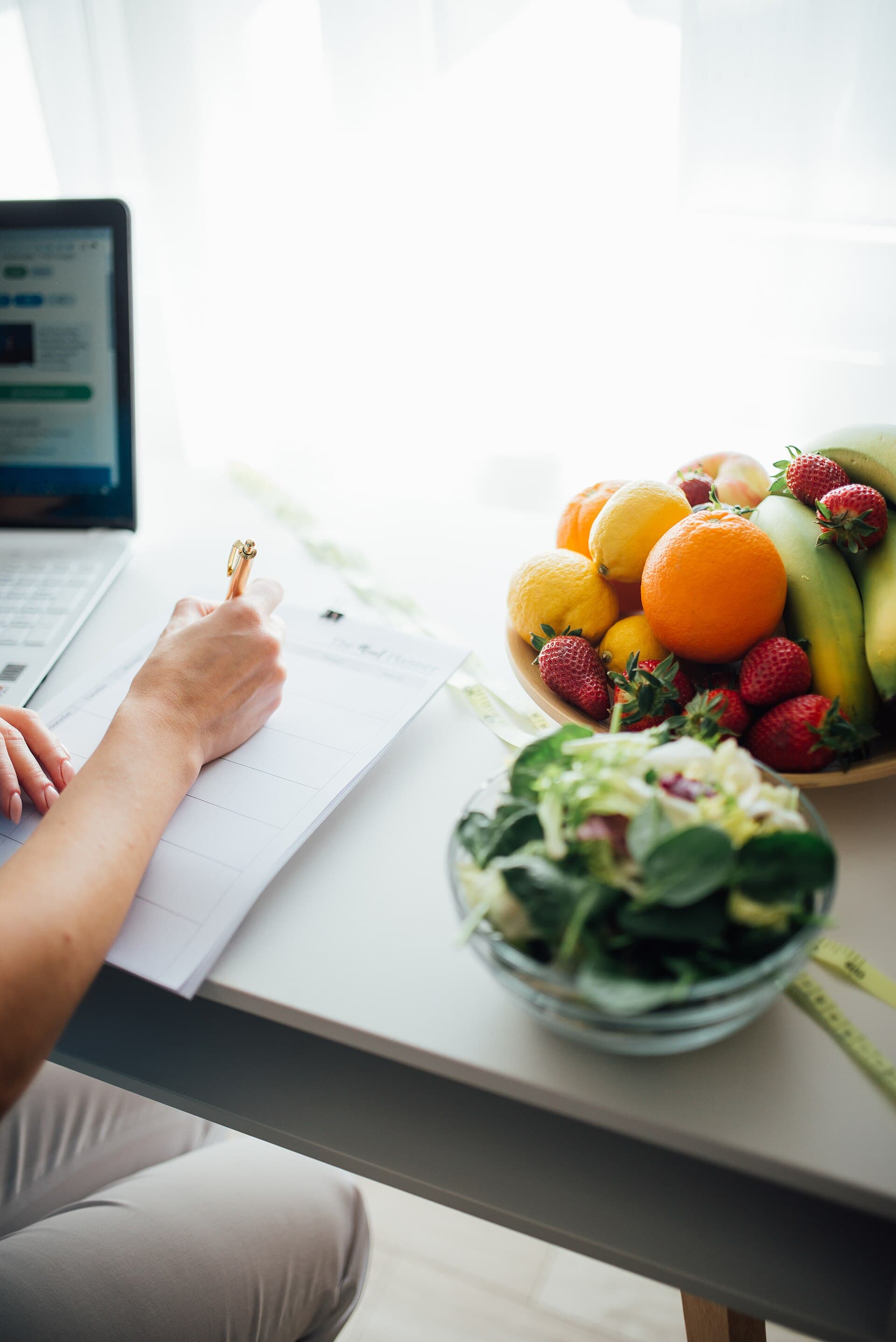 Plano alimentar junto de fruta e vegetais frescos numa mesa iluminada